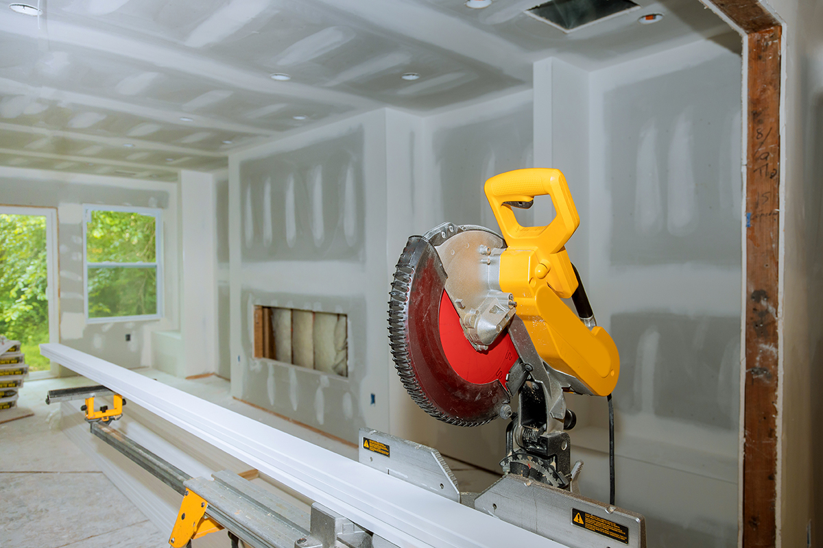 Details new home installing construction building industry interior circular saw cutting wooden base molding